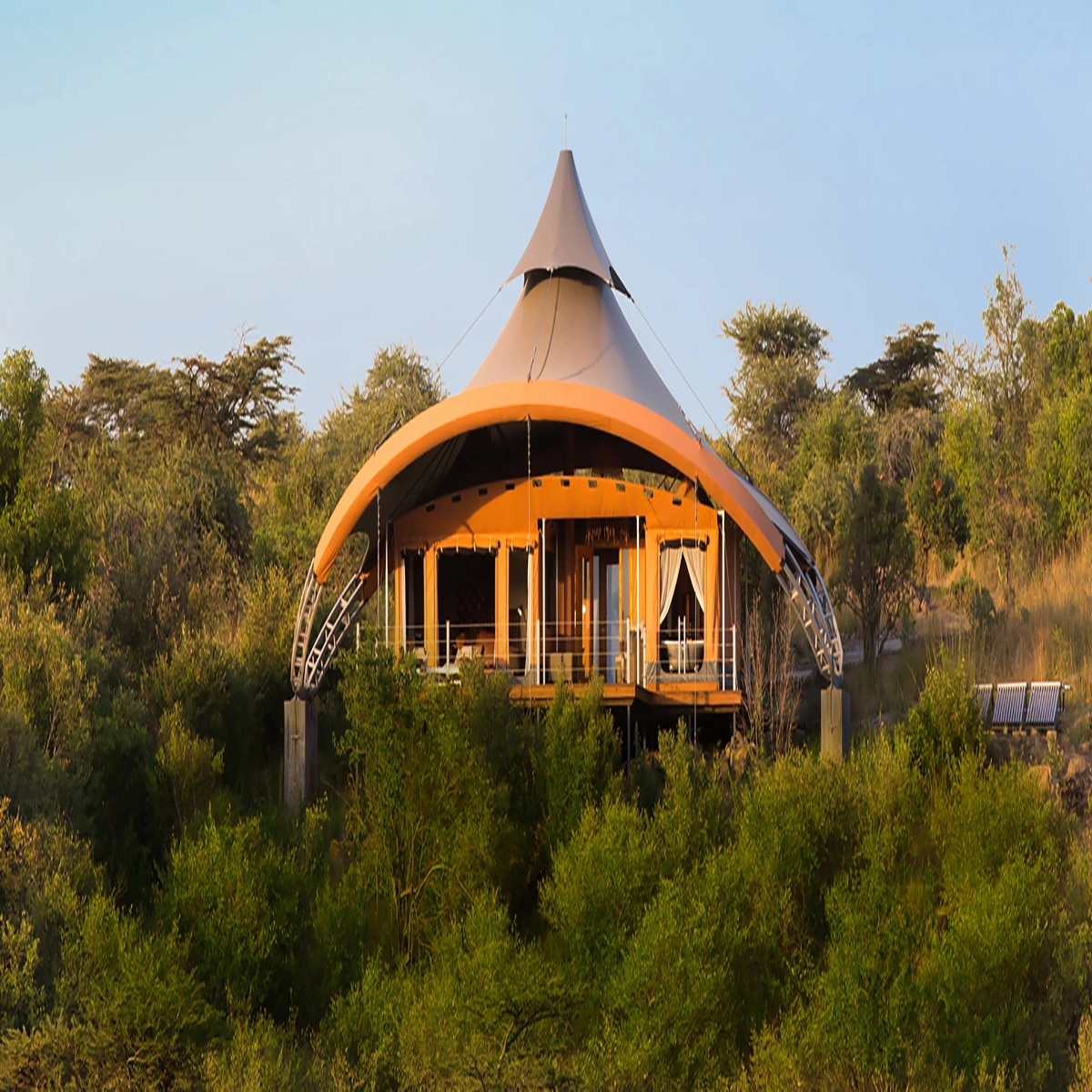 Exterior view of a luxury 5-star canvas suite at Mahali Mzuri with a private wooden deck overlooking the Kenyan wilderness.