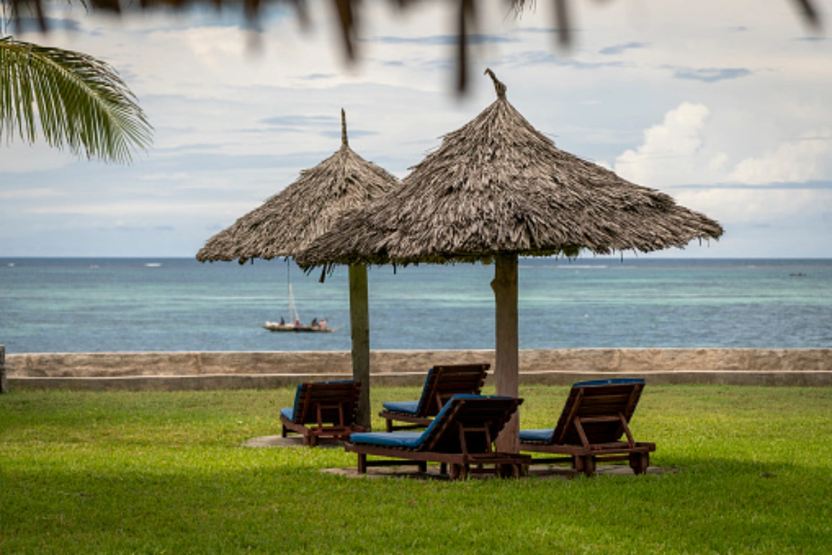 White sand beach and turquoise Indian Ocean waters lined with palm trees at Diani Beach Kenya