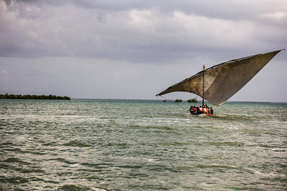 Traditional Swahili wooden dhow sailing along the tranquil tropical waters of the Lamu Archipelago
