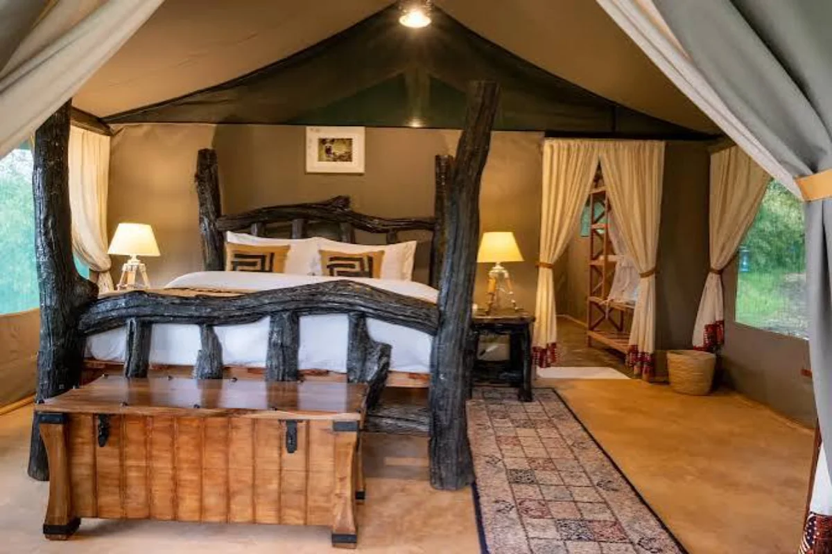 Canvas tented safari suite with open wooden deck set in an unfenced wilderness camp in the Masai Mara.