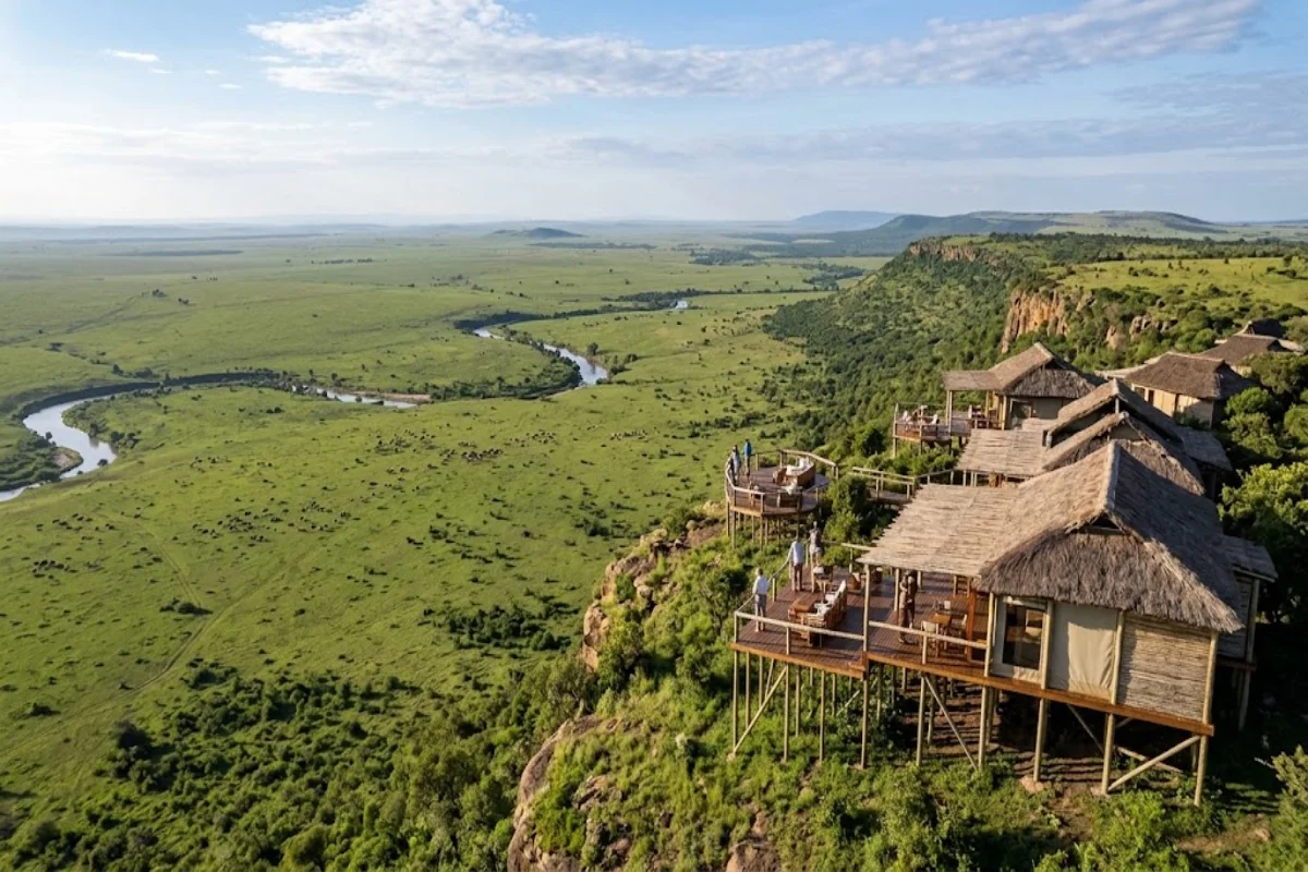 Elevated safari camp on Oloololo Escarpment overlooking green plains and Mara River basin in Masai Mara Kenya.